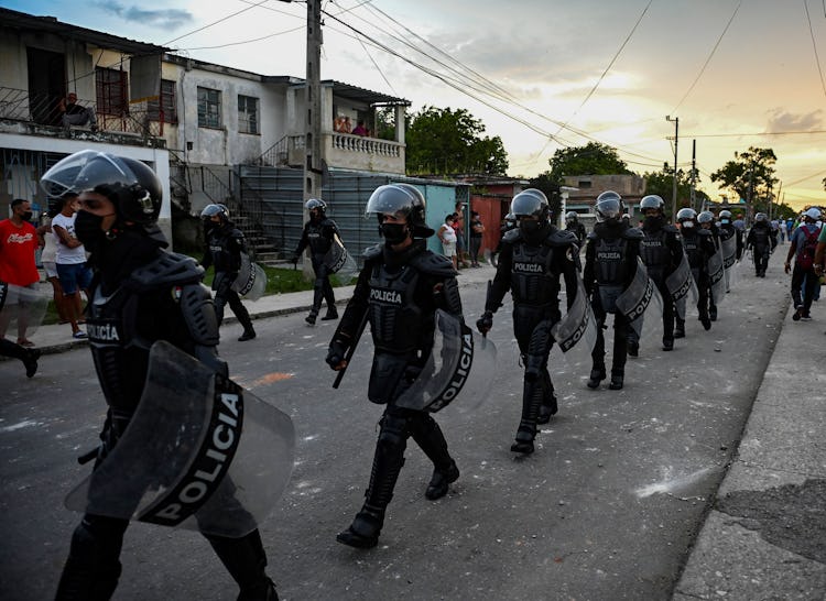 TOPSHOT - Riot police walk the streets after a demonstration against the government of President Mig...