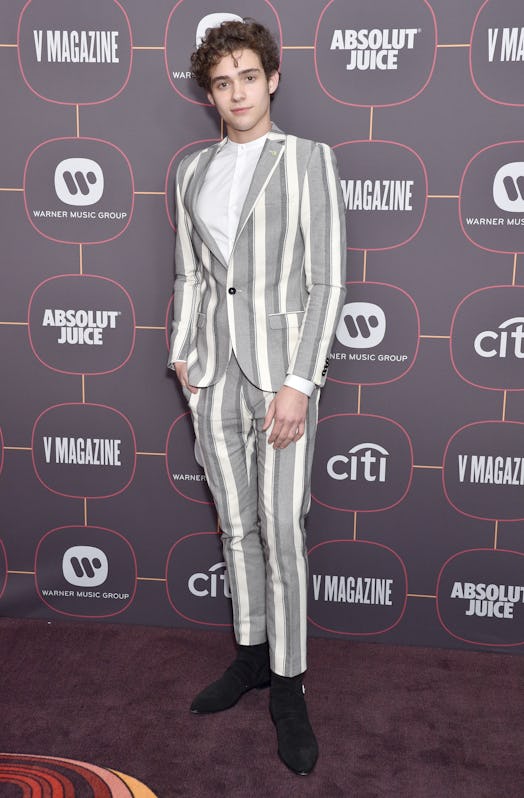 Joshua Bassett, shown here at a premiere while wearing a grey striped suit, is in his feels. 
