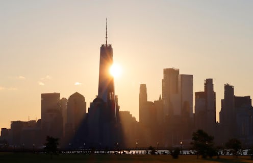 The sun rises behind lower Manhattan and One World Trade Center in midtown Manhattan in New York Cit...