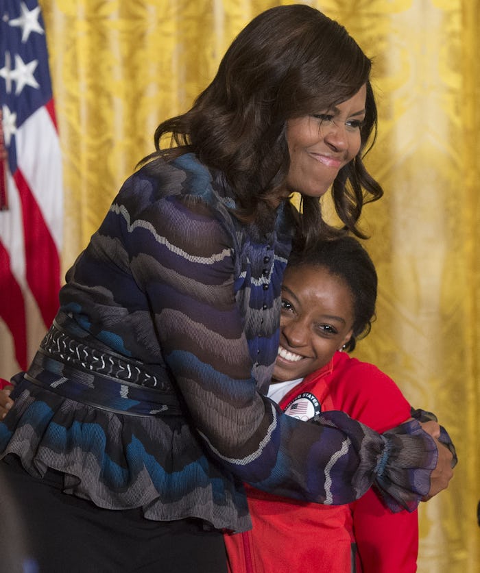 US First Lady Michelle Obama hugs US Olympic gymnast Simone Biles during a ceremony honoring the 201...