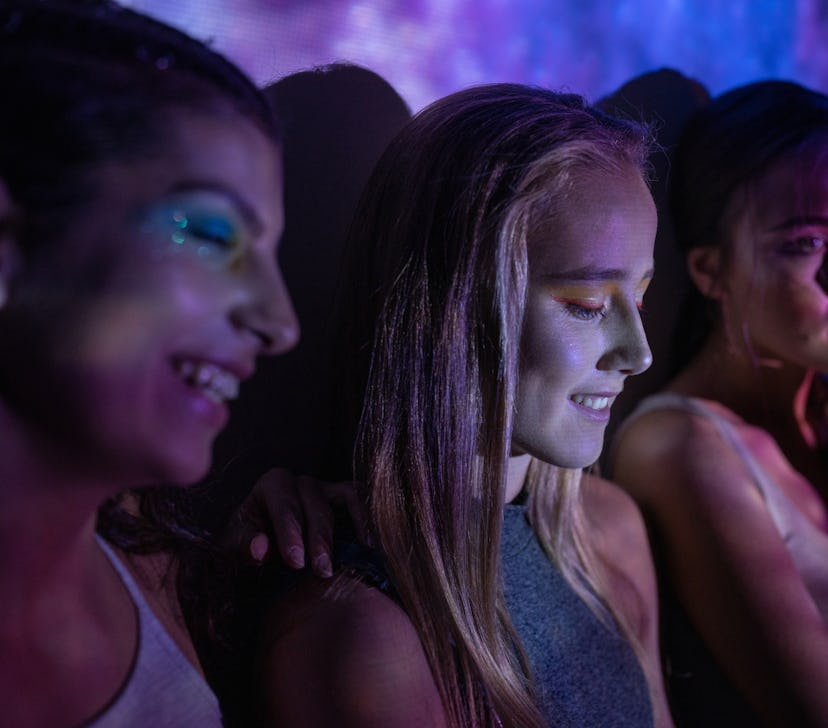 Photo of a teenage girls illuminated with neon lights, having fun together during the August 2021 fu...
