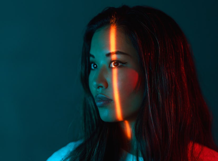 A portrait of a beautiful woman lit by neon colored lights during the August 2021 full moon in Aquar...