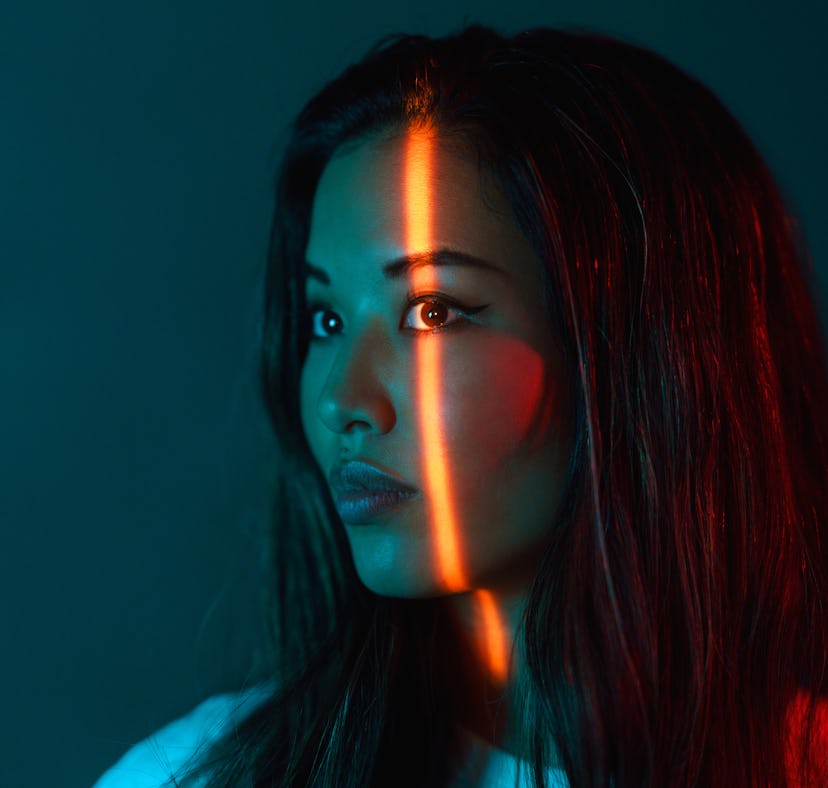 A portrait of a beautiful woman lit by neon colored lights during the August 2021 full moon in Aquar...