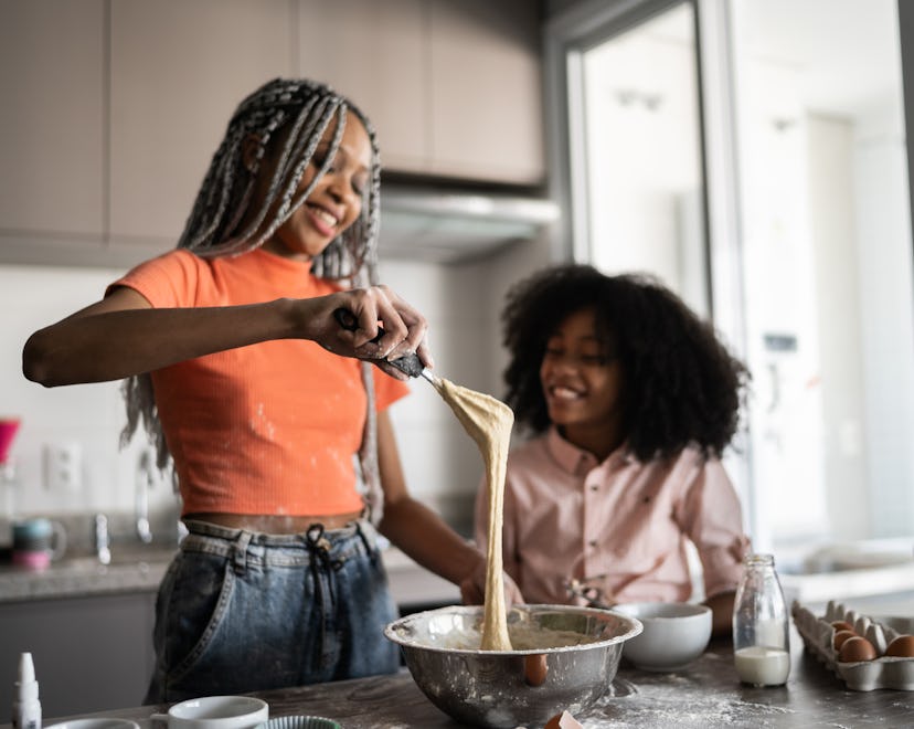 Sisters making a cake together at home
