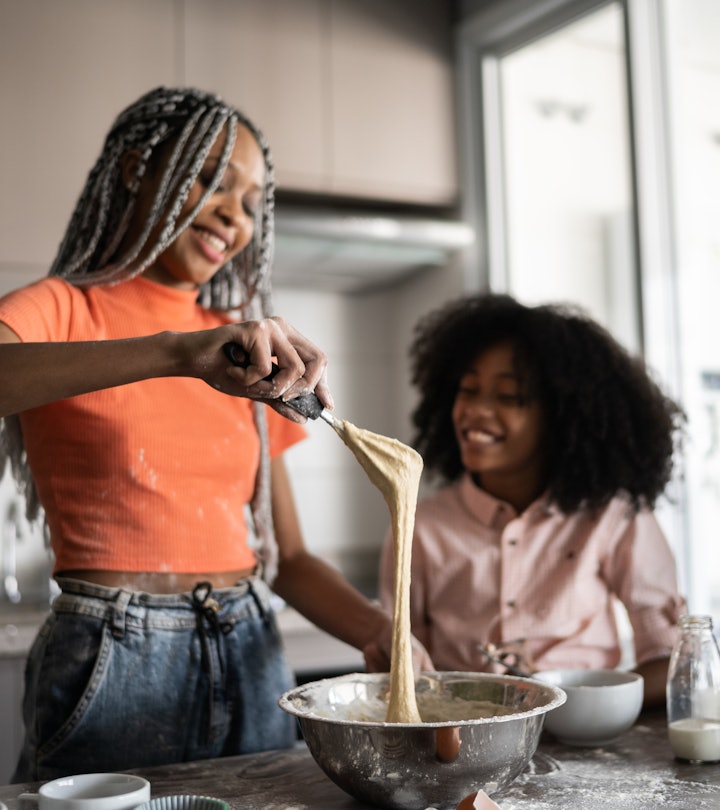 Sisters making a cake together at home