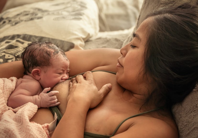 Mom, laying down and breastfeeding newborn 