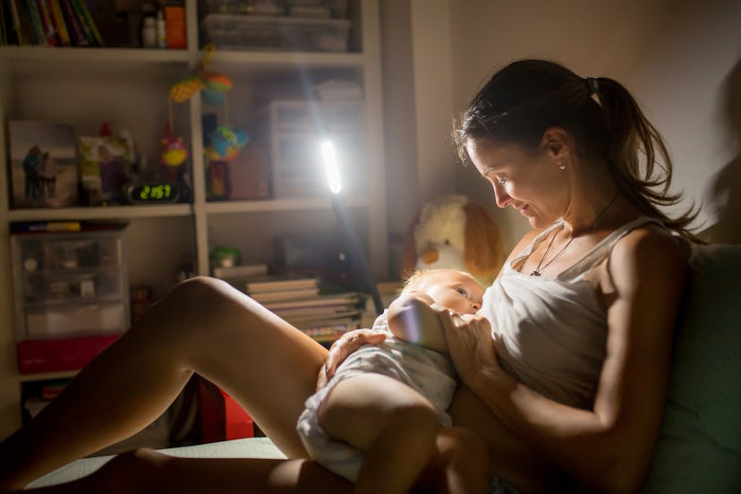 Mom breastfeeding baby in low light in the evening.