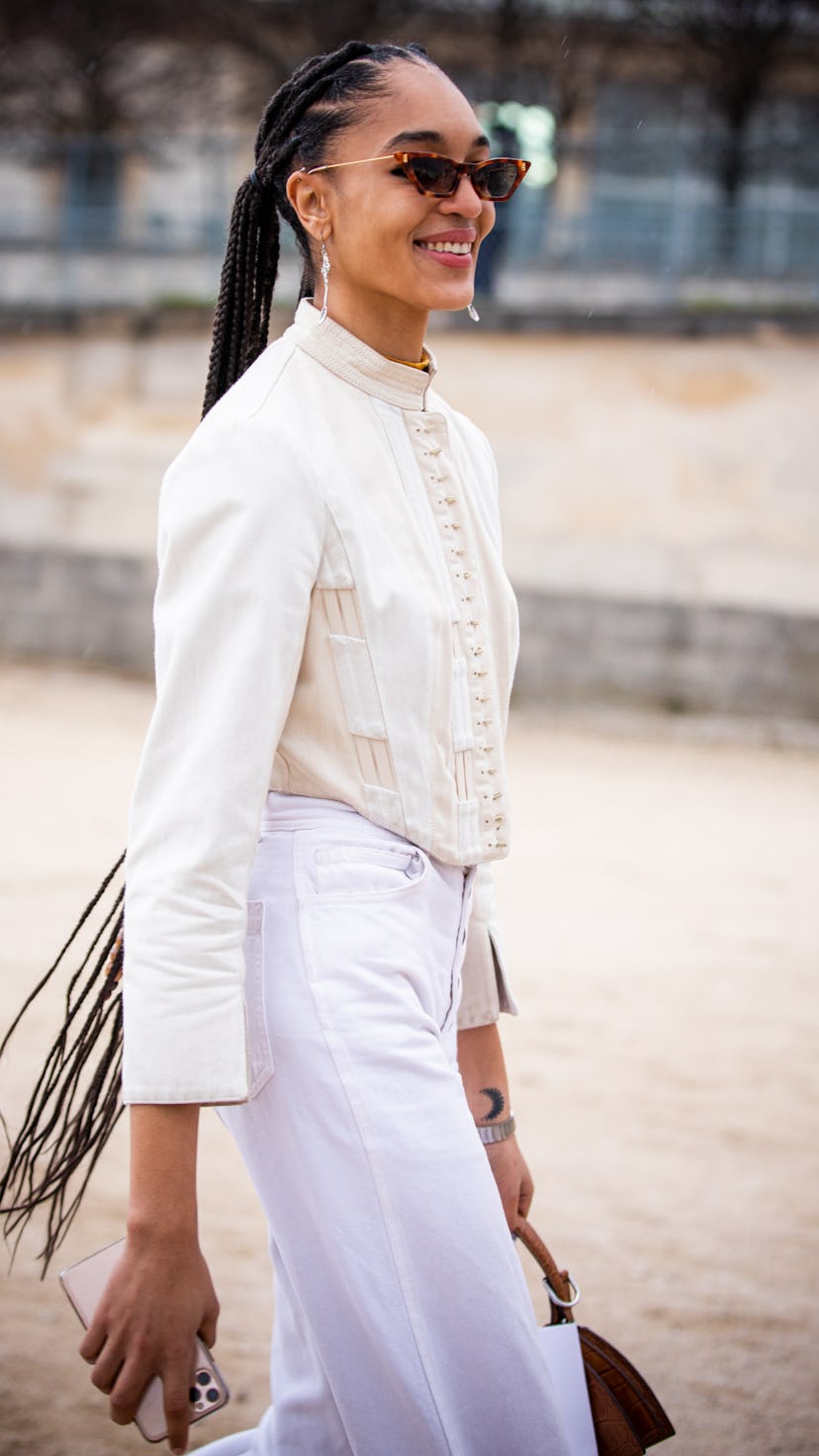 PARIS, FRANCE - FEBRUARY 25: Model Indira Scott, wearing a cream top and white pants,, is seen outsi...