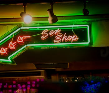 Neon lights posting the way to sex shops in the soho district of Central london