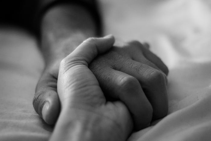 couple holding hands on bed