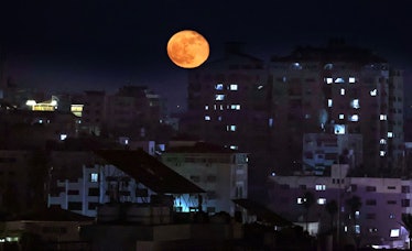 The "Super Blood Moon" rises above Gaza City in the Palestinian enclave, on May 27, 2021. (Photo by ...