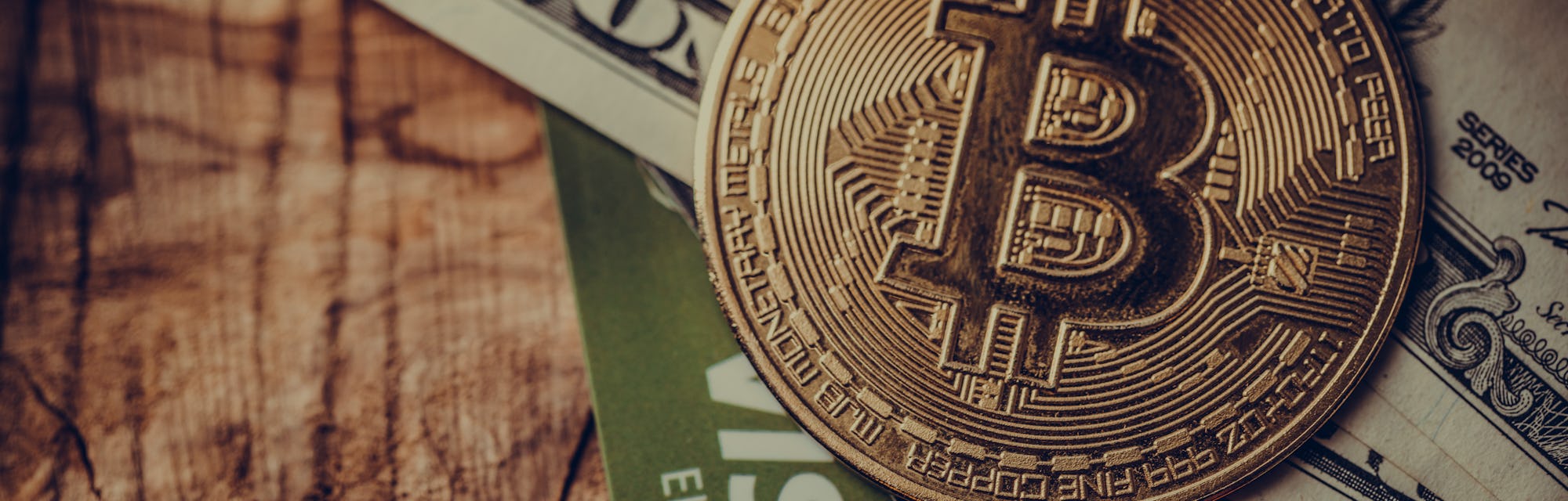 One coin of bitcoin on a black brown with dollars and the cards Visa , Mastercard