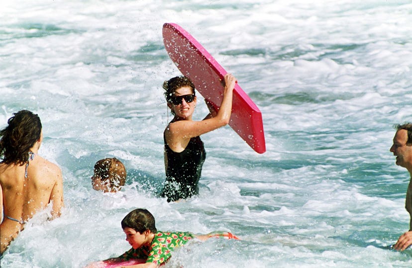 Princess Diana playing with kids in the waves.