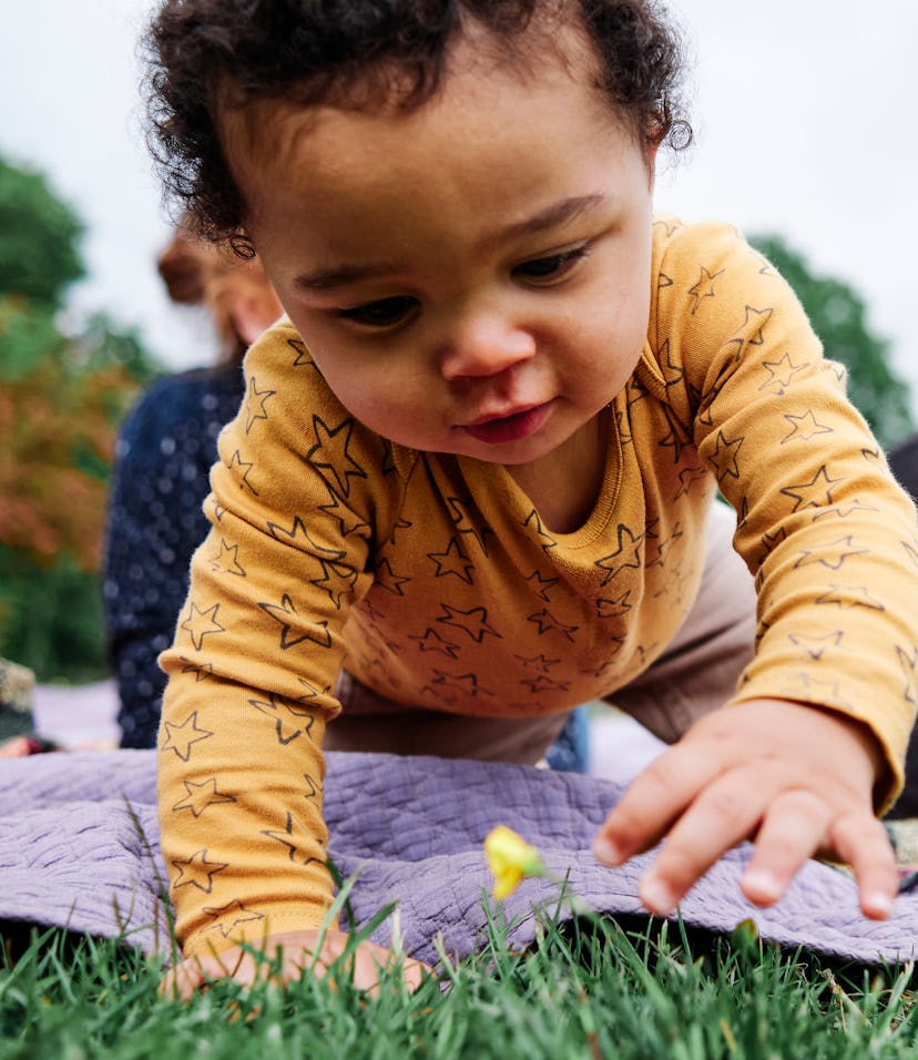 adorable baby boy playing in grass in article about one-syllable boy names