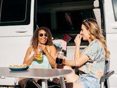 Women enjoying drinks and nachos outside of a van, having TikTok's viral boat dip.