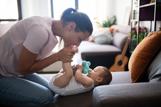 Mother playing with her baby at home in an article about one-syllable boy names
