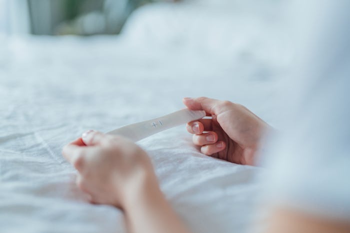 Close-up shot of unrecognisable Asian woman holding a pregnancy test kit and waiting for the result ...