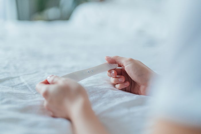 Close-up shot of unrecognisable Asian woman holding a pregnancy test kit and waiting for the result ...