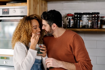 A young interracial couple kissing but hoping to avoid beard burn from a scruffy beard