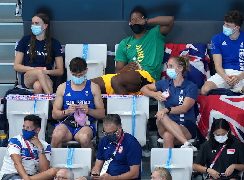 Great Britain's Tom Daley knits in the stands during the Women's 3m Springboard Final at the Tokyo A...