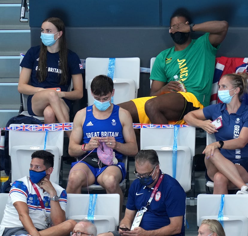 Great Britain's Tom Daley knits in the stands during the Women's 3m Springboard Final at the Tokyo A...