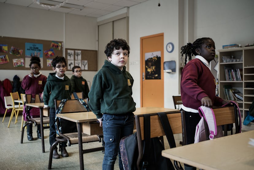 French students wear casual school uniforms of red sweaters and green hoodies with jeans