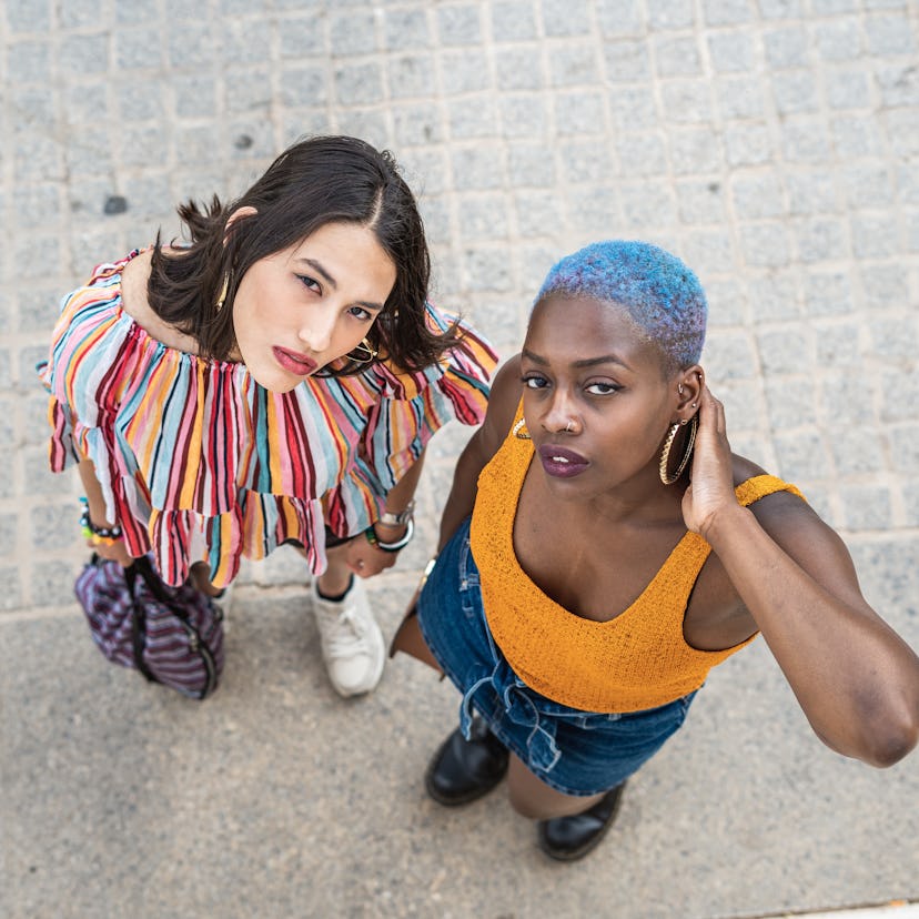 Two women — one Leo, one Virgo — looking up at the camera, wondering their friendship compatibility.