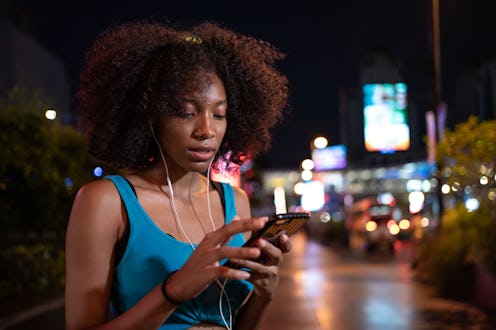 A person wears a tank top while listening to headphones and texting. Texting when you're mad at some...