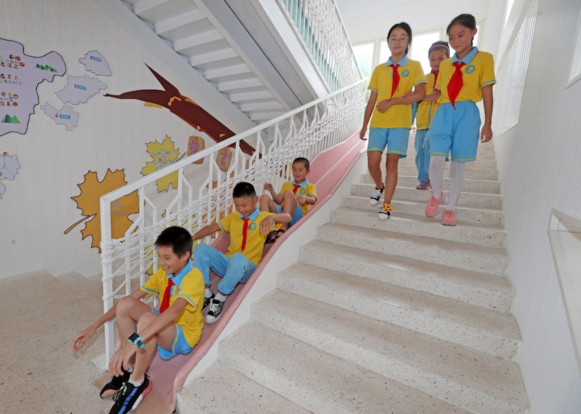 Chinese children wear bright blue and bright yellow with red ties as a school uniform. The girls tak...