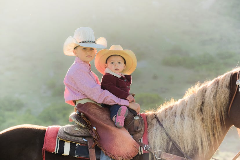 Young Boy Rides His Horse With His Baby Cousin As His Dad Watches Them