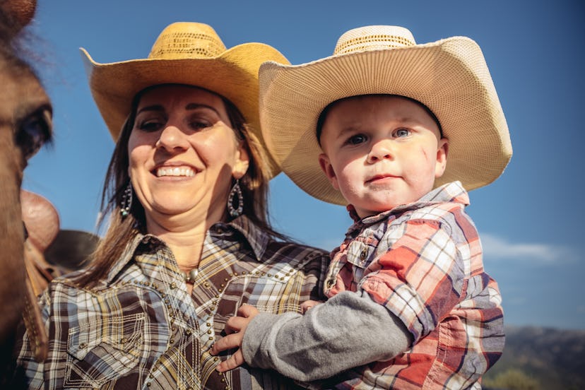 Portrait of  cowgirl mother and baby boy  outdoors. Horse in the background.  Outside Salt Lake City...
