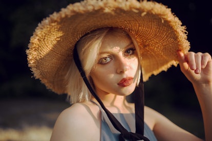 young woman wearing straw hat gazes into camera, after reading about the best day in September 2021 ...