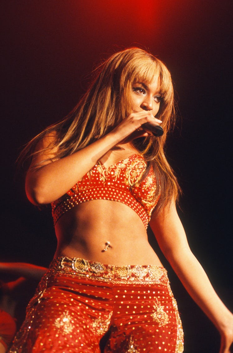 Beyonce in a red and gold outfit with her belly button on show in the Netherlands in 2003.
