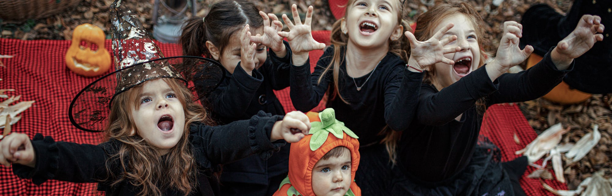 Little girls dressed playing as witch at Halloween in the forest