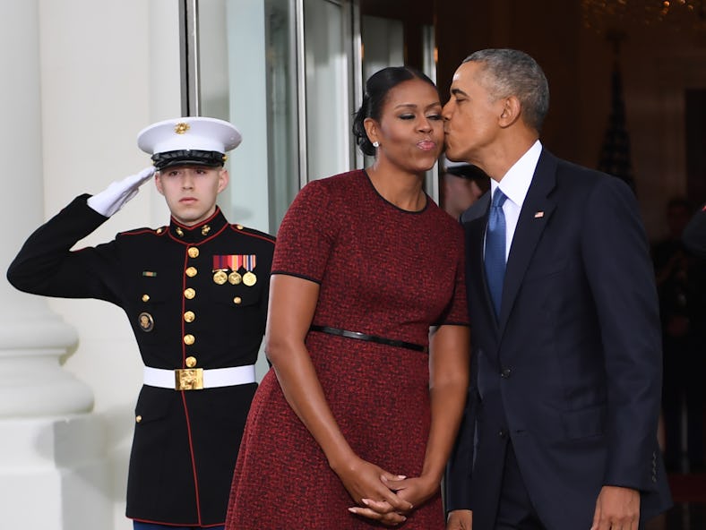 US President Barack Obama and First Lady Michelle Obama kiss as they prepare to greet President-elec...