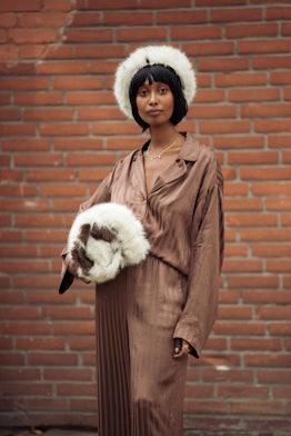 COPENHAGEN, DENMARK - AUGUST 10: Mona M. Ali wearing brown silk suit, fur har and fur bag outside Ge...