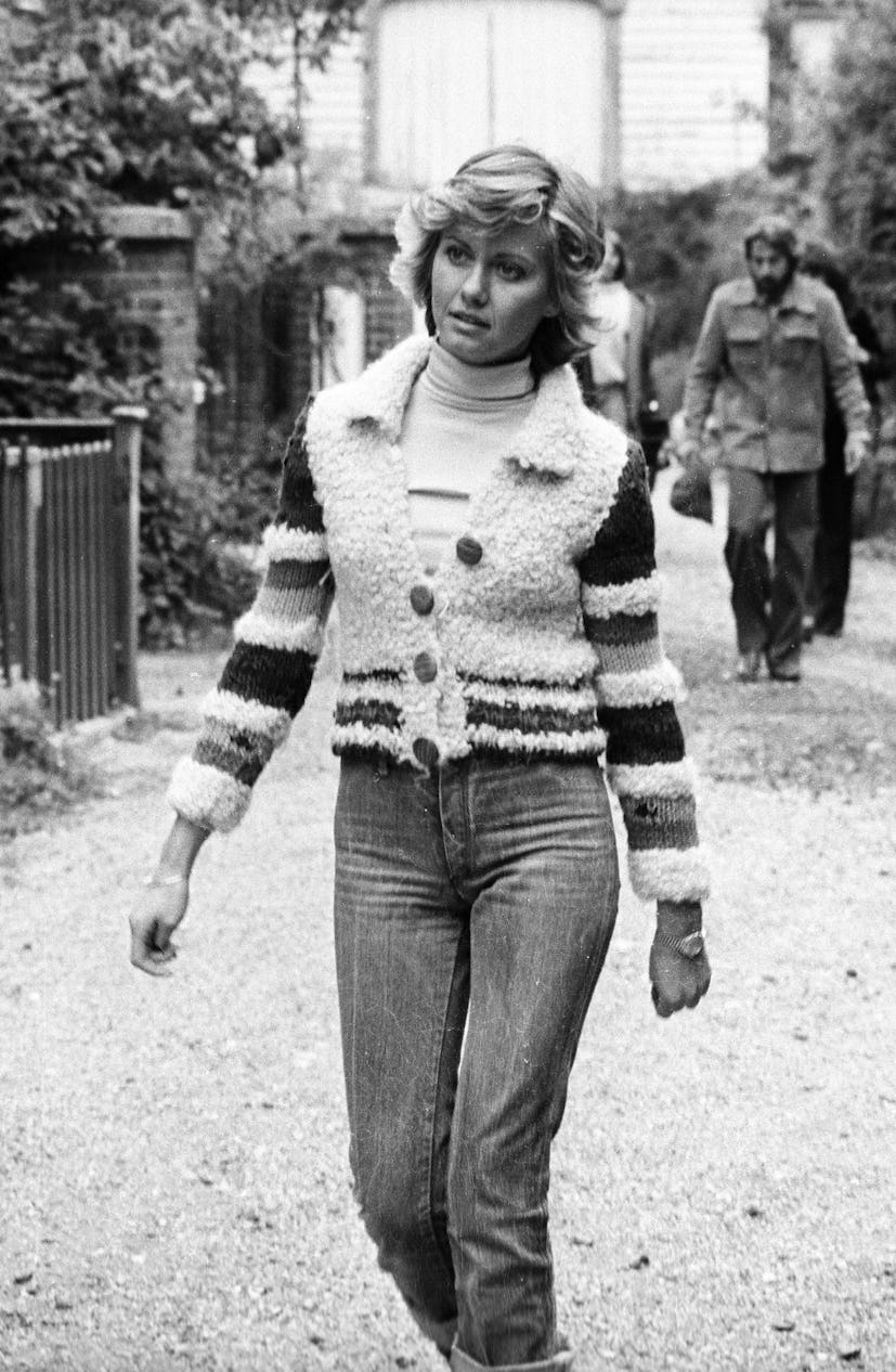'70s denim: Olivia Newton-John wears cuffed jeans and a fuzzy cardigan while filming her first music...