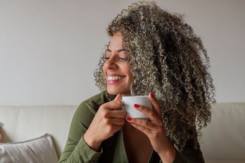 Latin woman from Bogotá Colombia between 40 and 49 years old, sitting on the sofa in her living room...