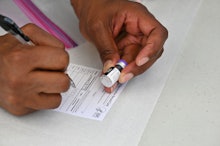 TOPSHOT - A healthcare worker fills out a Covid-19 vaccination card at a community healthcare event ...