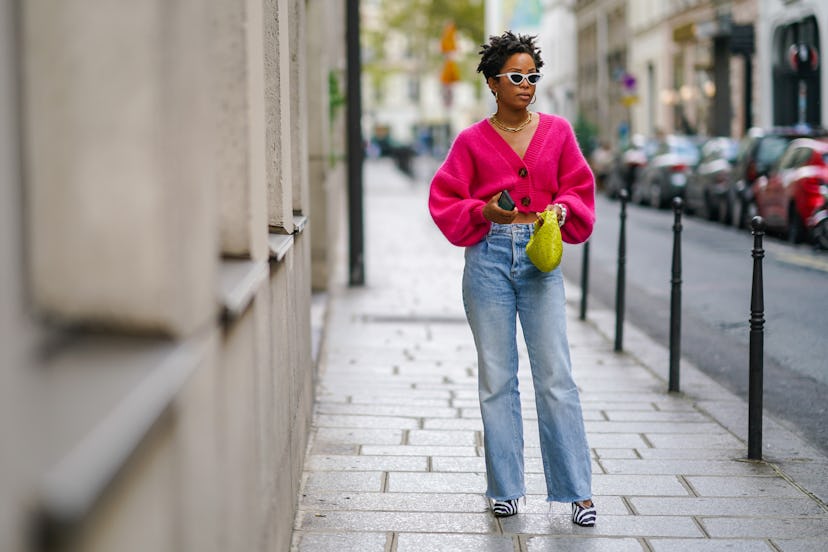 A woman with denim jeans walking down a street