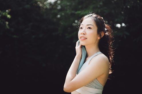 Asian beautiful young woman wiping the sweat from her neck with a towel.