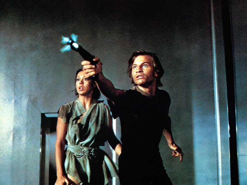 Jenny Agutter watches as Michael York shoots a gun in a scene from the film 'Logan's Run', 1976. (Ph...