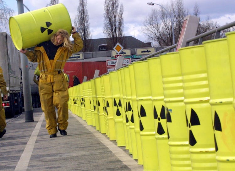 A Greenpeace militant carries a drum painted with a radioactivity sign 13 March 2001 on the Pont de ...