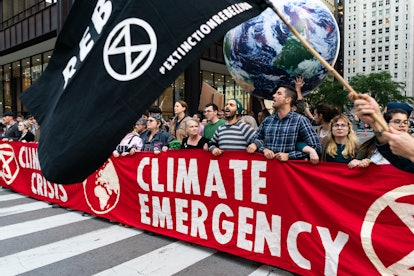 Demonstrators, carrying banners that read "Climate Emergency," shut down the corner of Randolph and ...