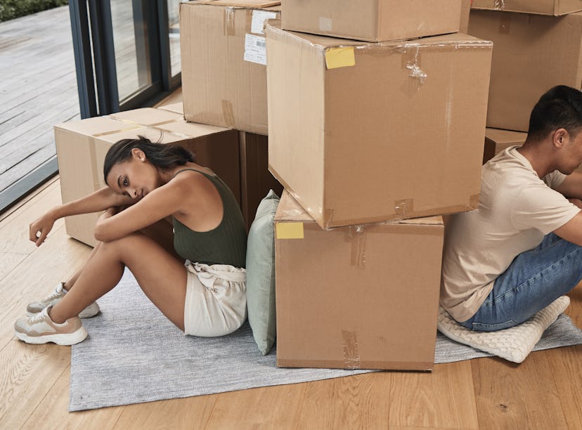 two roommates who might have a toxic relationship surrounded by boxes in their apartment.