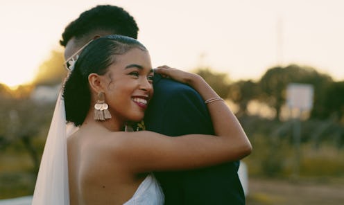 Cropped shot of a happy newlywed couple standing together and hugging after their wedding