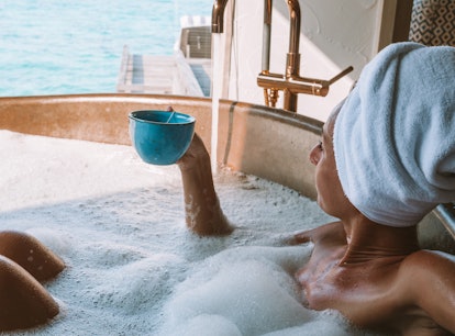 Woman in hot tub relaxing and enjoying the tropical sea view
