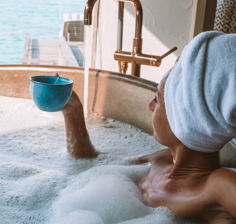 Woman in hot tub relaxing and enjoying the tropical sea view