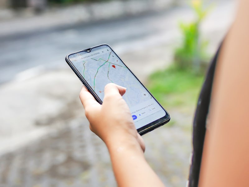 Bali,Indonesia, December 15, 2019 - Close up young woman using Google maps to check Covid - 19 commu...