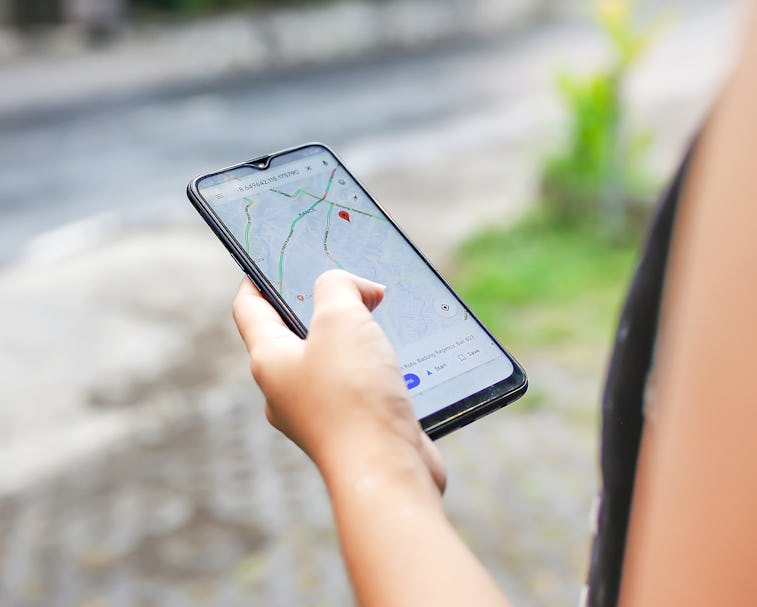 Bali,Indonesia, December 15, 2019 - Close up young woman using Google maps to check Covid - 19 commu...